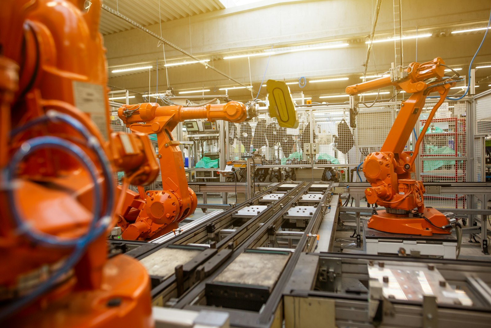 Autozulieferer: Fabrikhalle mit orangefarbenen Industrierobotern
