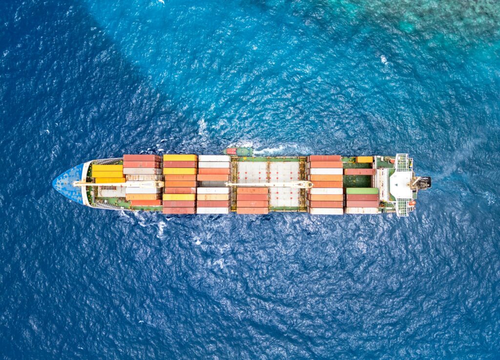Exportwirtschaft: Luftaufnahme eines beladenen Frachtschiffs auf dem Ozean