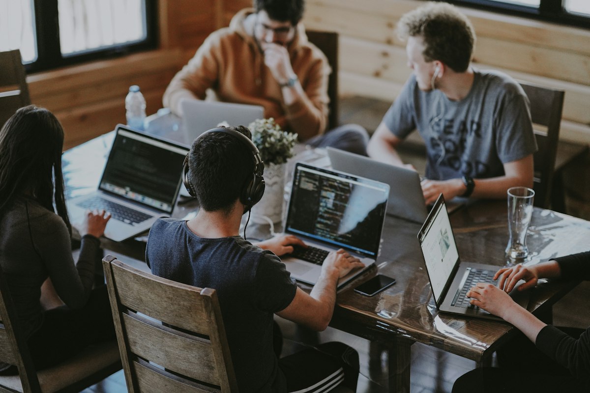 Vier-Tage-Woche im Team: Mitarbeitende arbeiten gemeinsam an Laptops