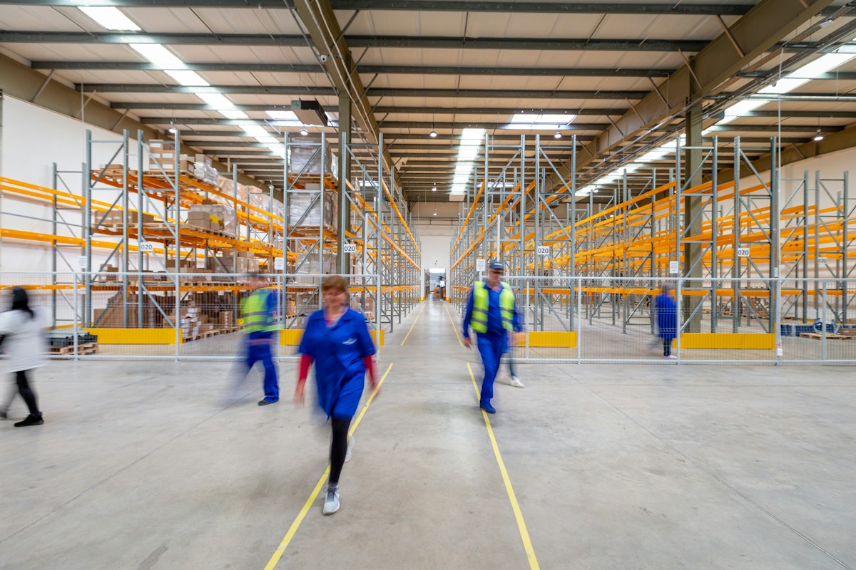 Lieferketten: Mitarbeiter in einem Logistiklager mit Regalen