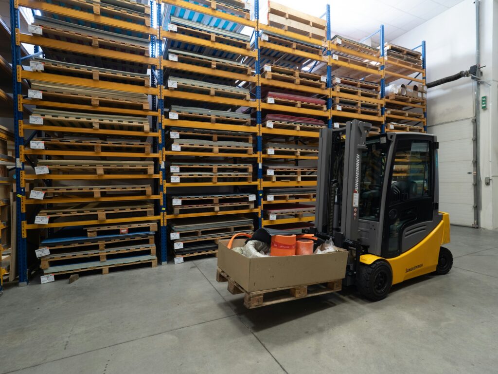 Lieferketten: Gabelstapler transportiert eine Kiste durch ein Lagerhaus