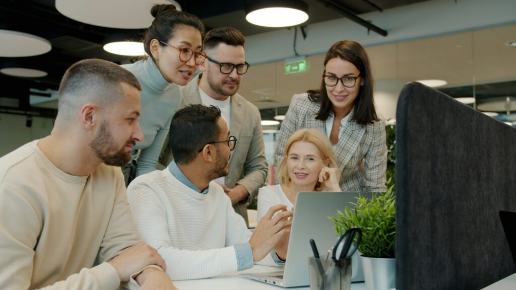 Rolle des Managers: Team arbeitet gemeinsam an einem Laptop im Büro