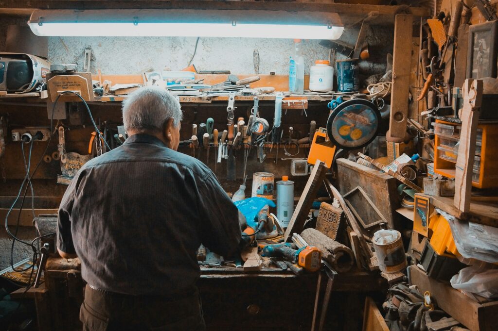 Unternehmensnachfolge im Handwerksbetrieb: erfahrener Unternehmer an der Werkbank