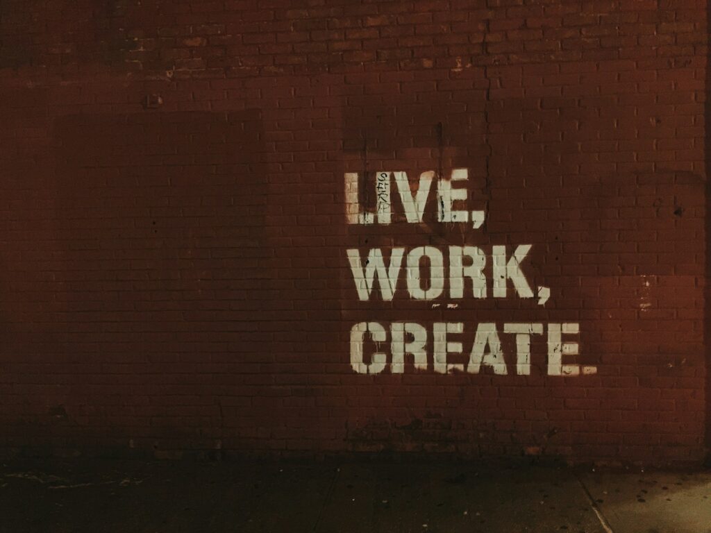 Vier-Tage-Woche und Work-Life-Balance: Backsteinwand mit dem Schriftzug Leben, Arbeiten, Schaffen