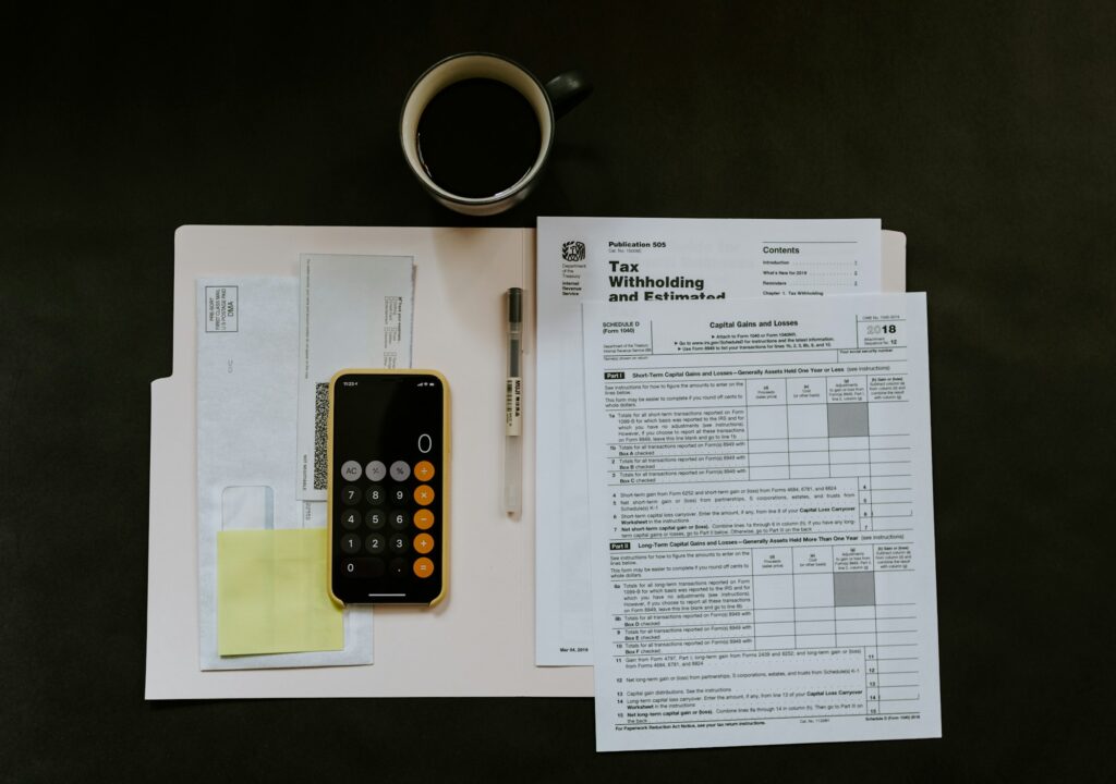 Working Capital Management: Rechnungen, Taschenrechner und Smartphone auf dem Schreibtisch